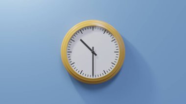 Saat on buçukta mavi bir duvarda parlak turuncu bir saat. Saat 10: 30 ya da 22: 30.