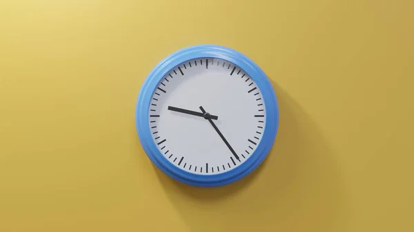 橙色墙上的一个光滑的蓝色钟 九点二十四分 时间是09 24或21 — 图库照片