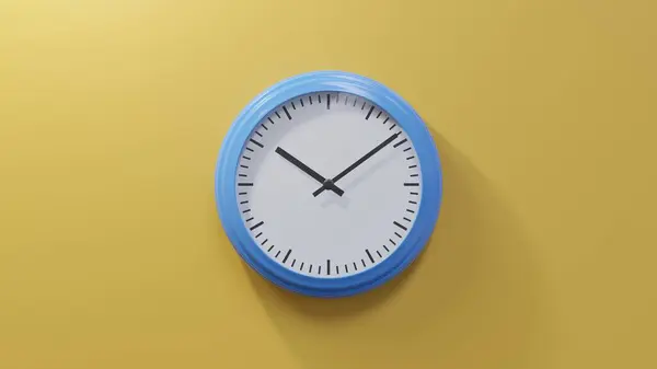 橙色墙上的一个光滑的蓝色时钟在九点十分 时间是10 09或22 — 图库照片