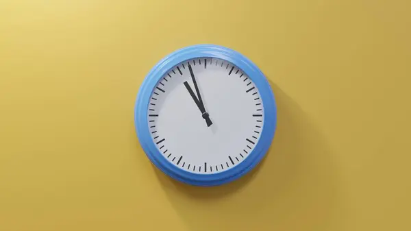 早上10点57分 橙色墙上的一个光滑的蓝色钟 时间是10 57或22 — 图库照片