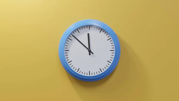 中午11点52分 橙色墙上的一个光滑的蓝色钟 时间是11 52或23 — 图库照片