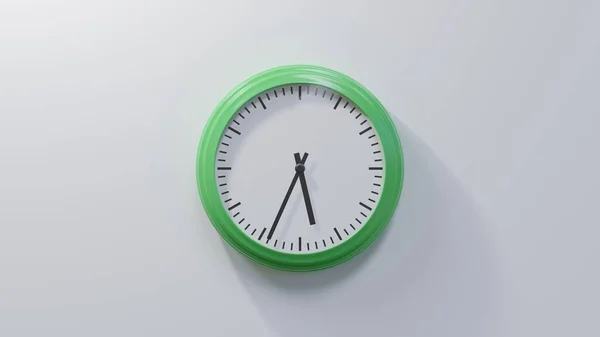 34過去5で白い壁に光沢のある緑の時計 時間は05 34または17 34です — ストック写真