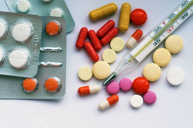Tablet hastalıklarının tedavisi için bir sürü bir masada evde dağılmışlardır. Masadaki diğer ilaçlar. Vitaminler bir masada evde. Hastanın ısısını ölçmek için termometre