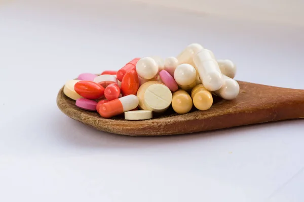 Tablet hastalıklarının tedavisi için bir sürü bir masada evde dağılmışlardır. Masadaki diğer ilaçlar. Vitaminler bir masada evde. Hastanın ısısını ölçmek için termometre