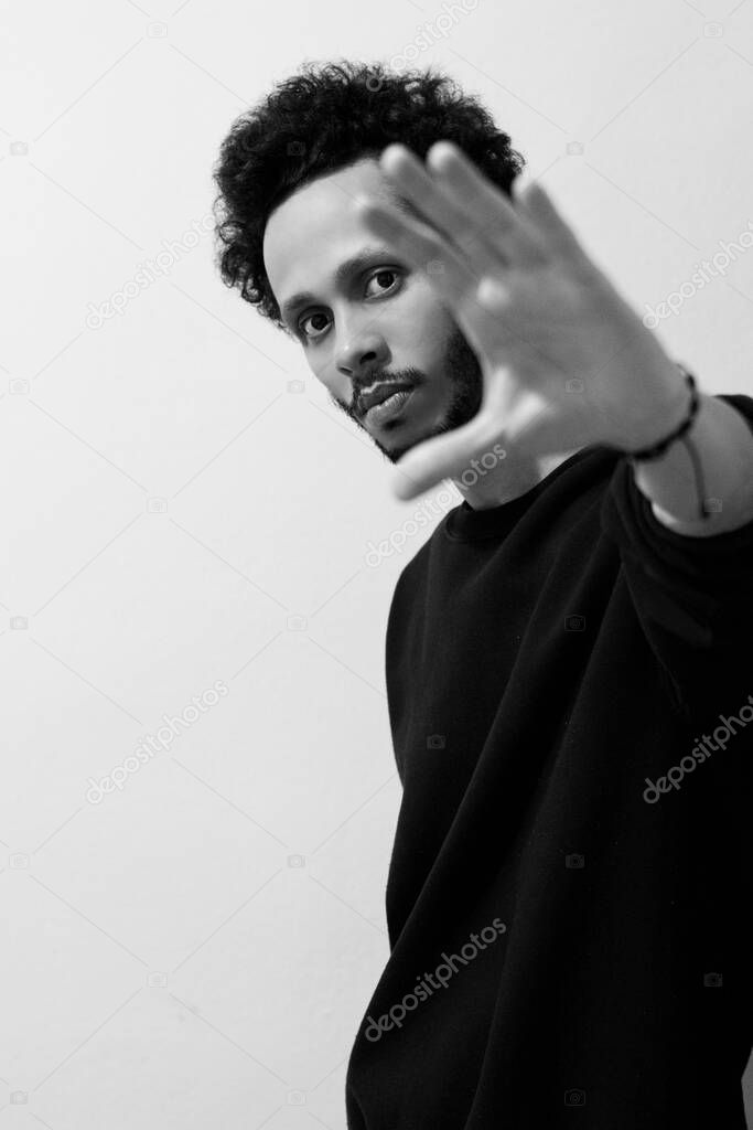 Man in black coat on white background, looking at the camera