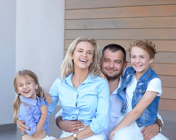 4人のお父さん お母さん 白と青の色の光の服の背景にある2人の娘の美しい幸せな若い家族 銀行の信用と保険の概念 現代的で友好的なカップル — ストック写真