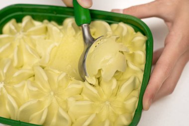 Bir kepçe taze şam fıstıklı dondurma şam fıstığı, nane elması ve limon genç bir kızın ellerinde. Mutfak aletleri kavramı, güzel bir hayat. Yakın plan fotoğraf.