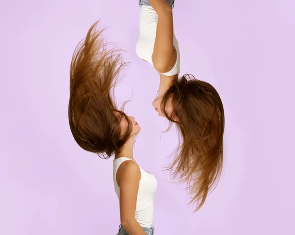 Twee mooie jonge yin en yang meisjes met vliegend haar ondersteboven. Evenwicht, harmonie en persoonlijkheidspsychologie Dualiteit concept. Haarverzorging, haardroging, conditioner. Kapsalon. — Stockfoto