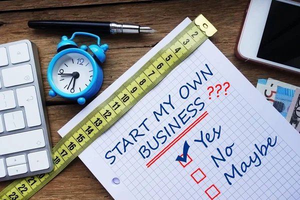 Start my own business question, conceptual image with personal agenda, computer keyboard and office objects on wooden table