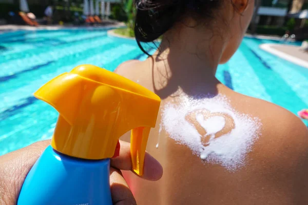 白いの日焼け止めクリームをハート型に女性の肩に日焼け止めの保護を適用します — ストック写真