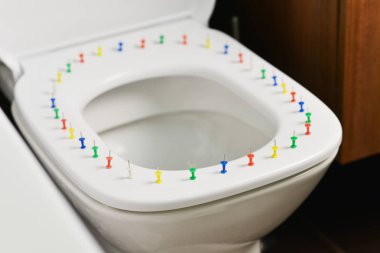 Ağrı ve diğer semptomlar dış renkli iğne, klozet ve onun kapağında renkli raptiye ile soyut resim