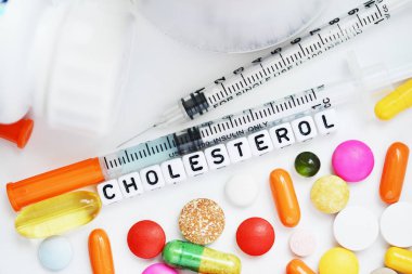 Sağlık sorunları kavramı ile beyaz arka plan üzerinde beyaz plastik boncuk renkli ilaç ilaçlarla kolesterol Word'den