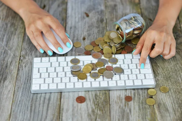 Businesswoman making money online, with cash coins on computer keyboard, online transaction concept