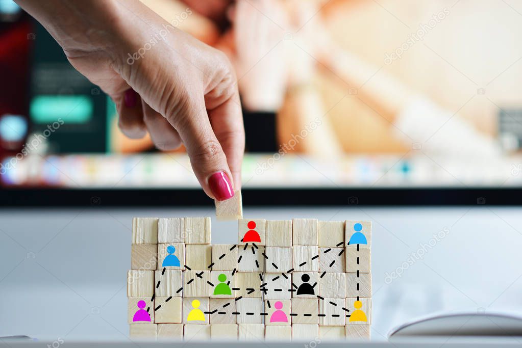 Business human resources concept with wooden cubes in front of office computer