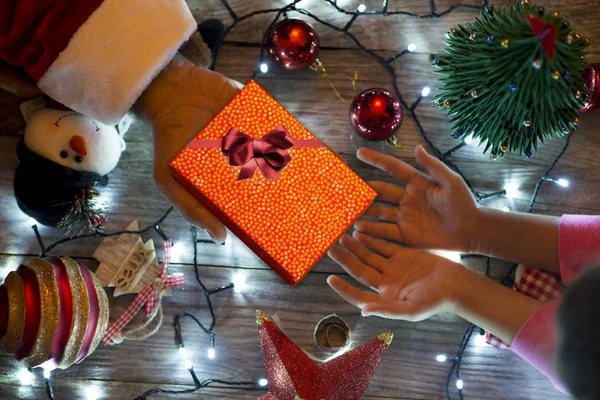 小さな子供へのクリスマス プレゼントを提供しているサンタ クロース — ストック写真