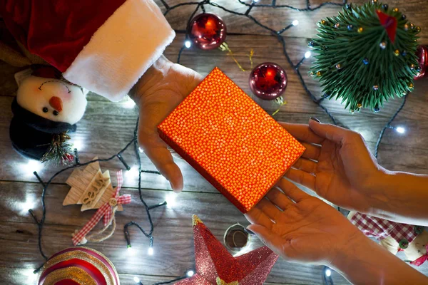 伝統的なクリスマスの装飾で女性にギフト ボックスを提供するサンタ手 — ストック写真