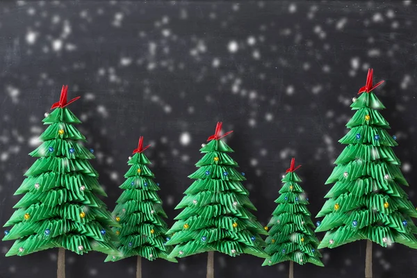 折り紙クリスマス ツリーは 暗い背景に緑の折り畳まれた紙を形成します — ストック写真
