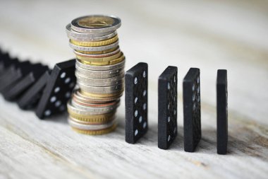 Siyah domino bloklarının düşüşünü durduran sikke yığını ile güçlü para birimi veya ekonomi kavramı