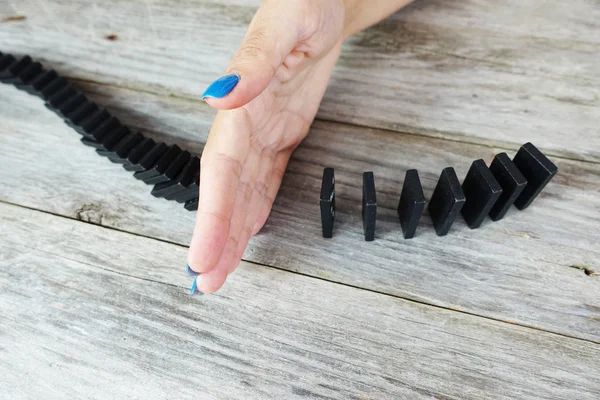 Womans Hand Stopping Domino Effect Wooden Table Aerial Top View — Stock Photo, Image