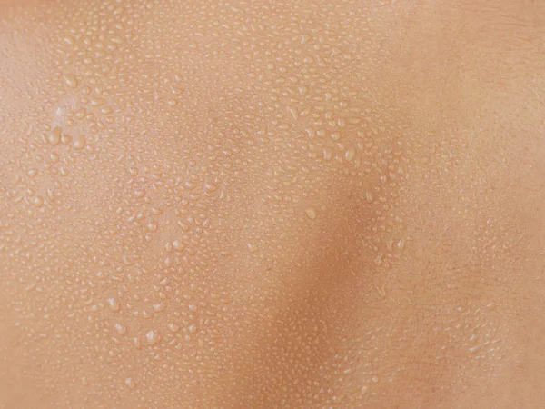 Water drops on woman skin, close up of wet human skin texture