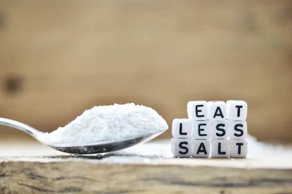 吃更少的盐信息写在木勺附近 充满了砂粒盐和摇床在质朴的背景 — 图库照片