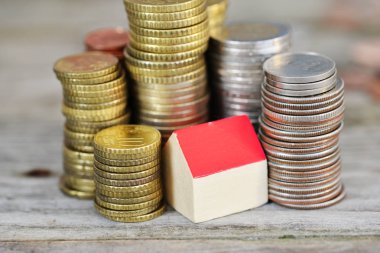 Minyatür ahşap ev ve nakit para yığını, bir yerleşim konsepti satın alma