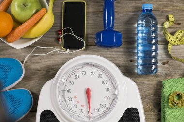 Analog ağırlık ölçeği, ahşap arka plan üzerinde spor nesnesi ve sağlıklı meyveler, sağlıklı yaşam tarzı kavramı