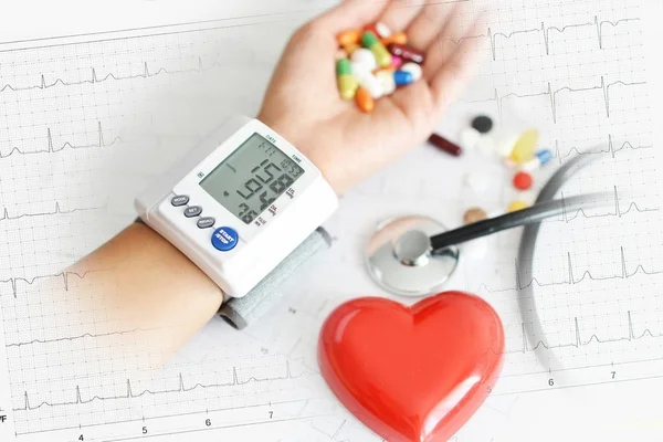 心電図の赤い心臓 聴診器および錠剤による高血圧患者の血圧のモニタリング — ストック写真