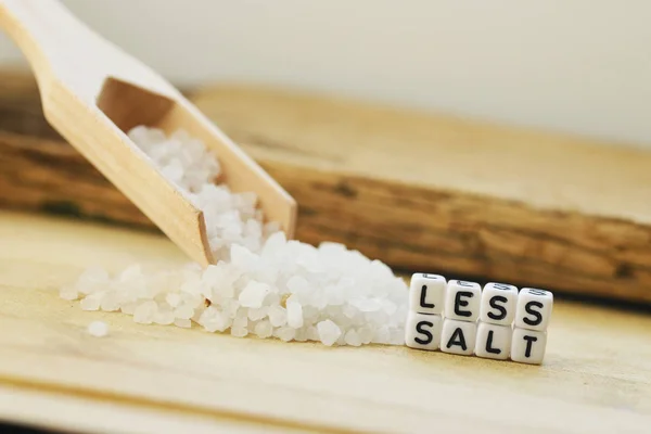 Less Salt Recommendation Wooden Spoon Granulated Salt Beige Background Zdjęcia Stockowe bez tantiem