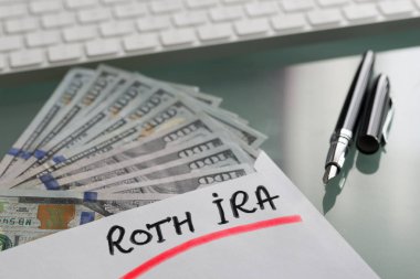 Roth Ira ile emeklilik konsepti için tasarruf nakit Abd doları ile beyaz zarf üzerine yazılmış
