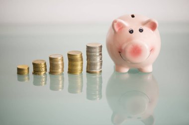 Kumbara ve para merdiveni cam masa üzerinde izole