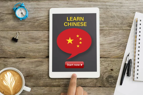Learn Chinese language through online webinar or course with white tablet on wooden desk