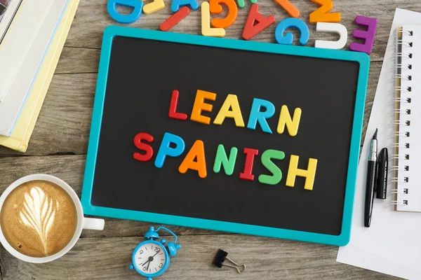 Learn Spanish advice written with colourful plastic letters on blackboard