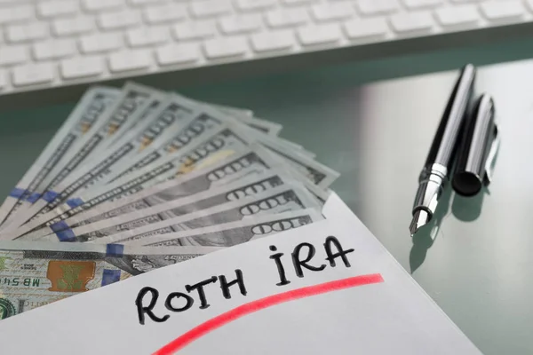 Savings for retirement concept with Roth Ira written on white envelope with cash US dollars