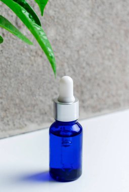 Mavi kozmetik deri serumuyla dolu bir şişe. Kadın kozmetik ürünleri için pipetli şişe.