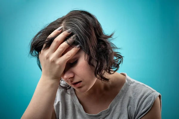 Mujer sostiene su mano sobre su cabeza. migraña femenina. dolores de cabeza en las mujeres —  Fotos de Stock