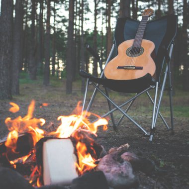 Ormanda kamp yapmak. İnsan doğada ateşin yanında gitar çalar. Yaz kampı. Doğada rahatlama