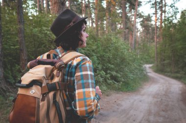 Ormanda kamp yapmak. Sırt çantalı kız ormanda yürüyor..