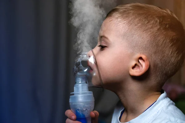 Inhalation child infant under five year. Boy making inhalation with nebulizer at home;