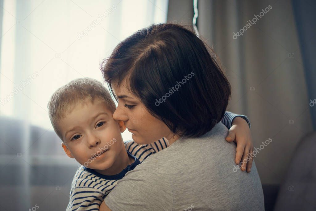 mother gently hugs her son at home. mother and son. mother's love