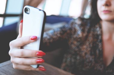 Güzel iş kadını restorandaki kameralı akıllı telefondan özçekim yapıyor. Kafede güzel bir esmer.