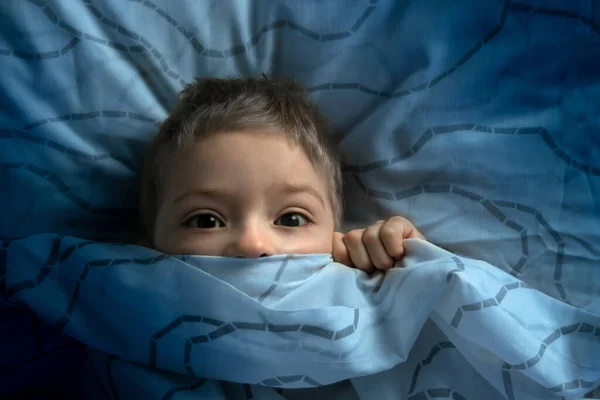 目を開けてベッドの中の少年 子供は暗闇を恐れている 悪夢や子供たちの恐ろしい夢に悩まされ — ストック写真