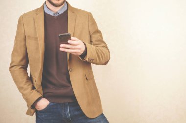 Gündelik tarzda bir adam. Elinde telefon olan ceketli bir adam. iş toplantısı