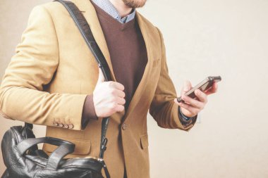 Gündelik tarzda bir adam. Elinde telefon olan ceketli bir adam. iş toplantısı