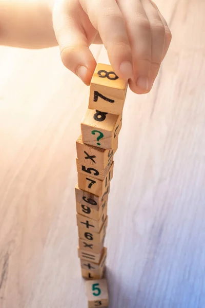 Wooden cubes with numbers. Teaching a child of preschool age mathematics. question mark. child learns numbers