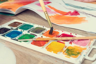 Beyaz kağıda fırça çizen çocuk eli. Çocuk üst görünümü çiziyor