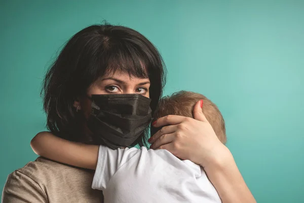 Mãe Uma Máscara Médica Segura Seu Filho Seus Braços Uma — Fotografia de Stock