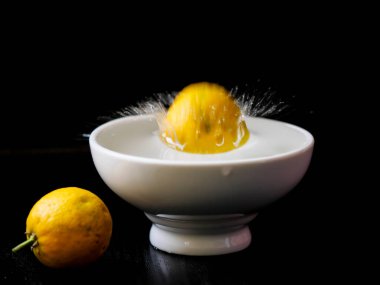Beyaz su kabına limon sıçrıyor.