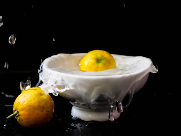 Beyaz su kabına limon sıçrıyor.