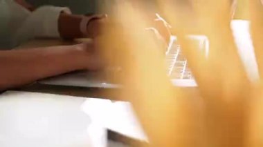 Ofiste çalışan genç bir kadın. Çekici bir ofis çalışanı masada oturuyor. İş kadını ofiste dizüstü bilgisayarda çalışmakla meşgul..